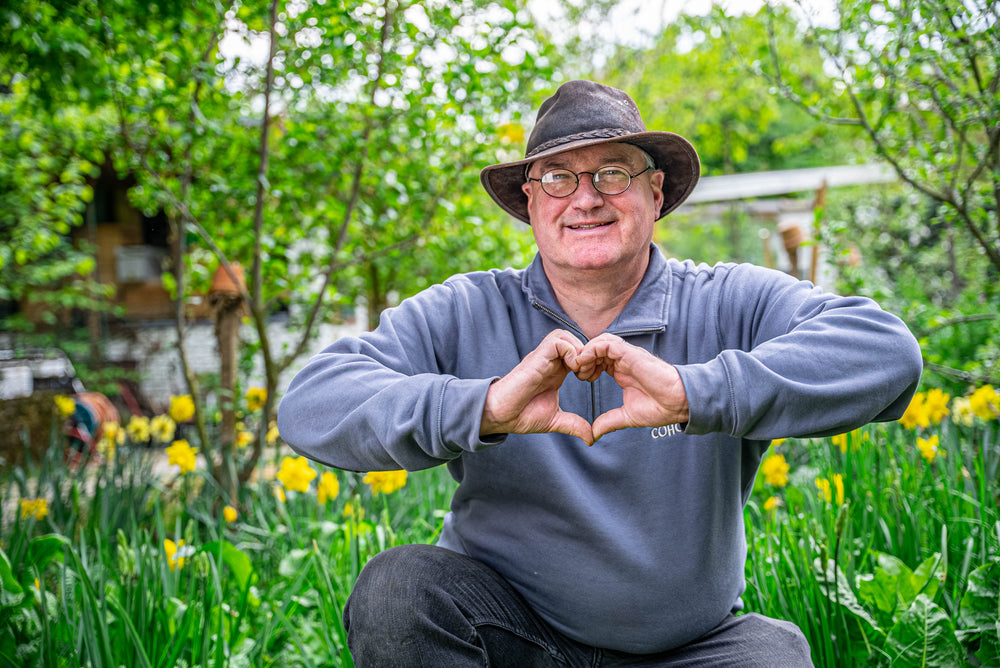 Gartencoach in seinem Garten zeigt ein Herz